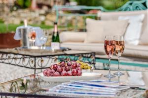 een tafel met twee glazen wijn en een schaal fruit bij Villa Cedri in Montecatini Val di Cecina