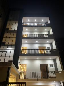 un edificio alto con 3 balcones y luces en él en Roomquet comfort inn, en Allahābād