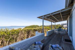 a deck with a view of the beach at Dunes Cottage in Plettenberg Bay
