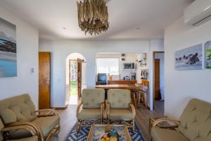 a living room with chairs and a dining room at Dunes Cottage in Plettenberg Bay