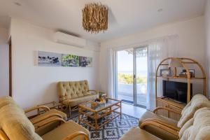 a living room with two couches and a tv at Dunes Cottage in Plettenberg Bay