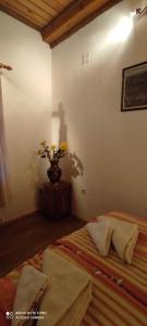 a bedroom with a bed and a vase of flowers at Apartman Šipak in Fužine