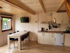 a kitchen and dining room with a table and chairs at Domek letniskowy Młyn in Karwieńskie Błoto Pierwsze