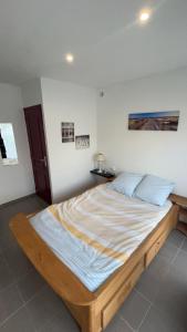 Bett in einem Zimmer mit Holzrahmen in der Unterkunft les gites de la Bellezza in Bois-de-Cené