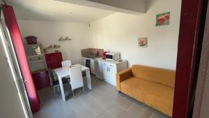 a small room with a couch and a small kitchen at les gites de la Bellezza in Bois-de-Cené