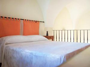 a bedroom with a large white bed with orange curtains at B&B Casina Margherita in Monteroni di Lecce