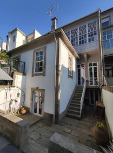 ein weißes Haus mit einer Treppe davor in der Unterkunft Alvares Cabral Apartamento C in Porto