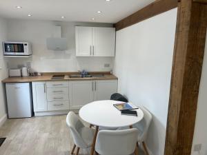 a kitchen with a white table and chairs and a counter at Acorn Lodge in Eastergate