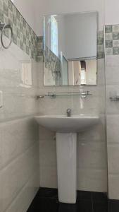 uma casa de banho com um lavatório branco e um espelho. em Springvalley Holiday Home em Badulla