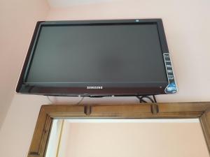 a television on a shelf above a window at Hostal La Parrilla in Mieses