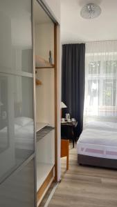 1 dormitorio con cama y armario de cristal en Aparthotel Slezák, en Litomyšl