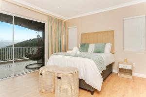 - une chambre avec un grand lit et un balcon dans l'établissement Coney Glen Penthouse, à Knysna