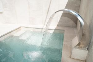 y baño con ducha y piscina de agua. en La Cueva de la Abuela, en Cenes de la Vega