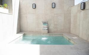 Una piscina de agua en el baño con una fuente. en La Cueva de la Abuela, en Cenes de la Vega