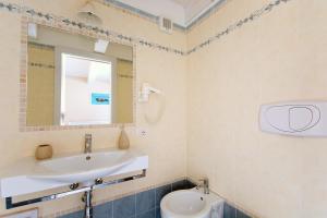 een badkamer met een wastafel, een spiegel en een toilet bij Residenza a due passi dal mare in Tropea