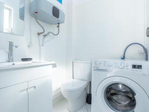 a white bathroom with a washing machine and a sink at Figueira Casino Center Apartment in Figueira da Foz