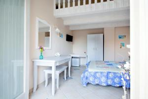 een kamer met een bureau, een tafel en een bed bij Residenza a due passi dal mare in Tropea