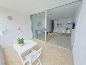 a living room with a white table and chairs at Apartamento en Playa San Marcos in Icod de los Vinos