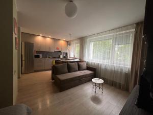 a living room with a couch and a kitchen at Elsertos namai in Telšiai