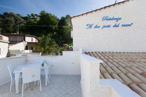 een witte patio met een tafel en stoelen aan een muur bij Residenza a due passi dal mare in Tropea