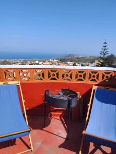 a patio with a table and two chairs on a balcony at ACORAN FAMILY in Firgas