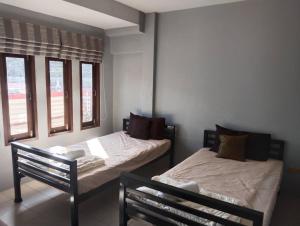 two beds in a room with two windows at Fueangfu Home Hostel in Chaweng