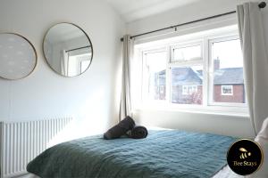 a bedroom with a bed and a large window at Bee Stays - Ambleside House in Warrington