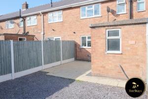 a brick house with a fence and a driveway at Bee Stays - Ambleside House in Warrington