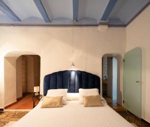 a bedroom with a large bed with a blue headboard at Casa Mediterránea - Quart de Poblet in Cuart de Poblet