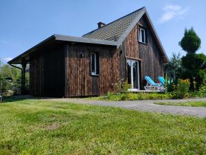 a small wooden house with a grass yard at Zielono Mi in Słajszewo