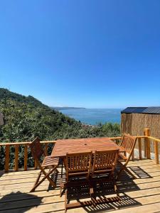 una mesa de madera y sillas en una terraza con vistas al océano en CİVRA BUNGALOV, en Sürmene