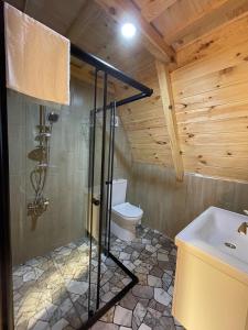 uma casa de banho com um chuveiro, um WC e um lavatório. em CİVRA BUNGALOV em Sürmene