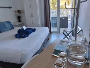 una camera con un letto e un tavolo con un bicchiere d'acqua di Lindsey Hôtel a Saint-Pierre