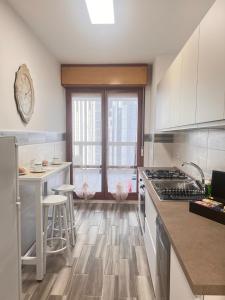 a kitchen with white cabinets and a wooden floor at City Home 77 in Naples