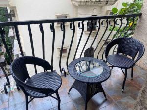 three chairs and a table on a balcony at Bandra’s Prime luxurious 2 BHK in Mumbai