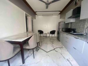 una cocina con 2 sillas y una mesa. en Bandra’s Prime luxurious 2 BHK en Bombay