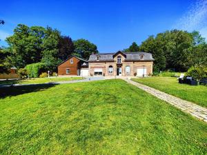 a large brick house with a large grass yard at La maison du bien-être 