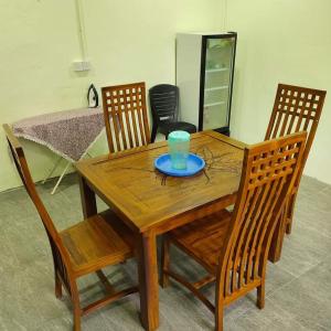 een houten tafel met een blauwe beker erop bij Raniah Homestay2 in Kuching