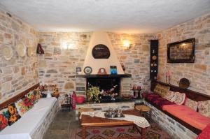 a living room with a fireplace and a stone wall at Archontiko Parisis in Lafkos