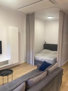 een woonkamer met een bank en een bed bij Apartament Sztolnia in Kowary