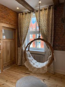 a room with a swing in front of a window at Apartments PSD - Anny Łajming 2C in Słupsk