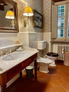 uma casa de banho com um lavatório, um WC e um espelho. em La Casa di Francesca tra le Colline di Lucca in Toscana em Lucca