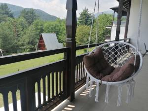 a porch swing with a view of a farm at Rusaliite Adventure House in Bachevo