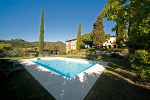 a swimming pool in a yard with trees and a house at La Casa di Francesca tra le Colline di Lucca in Toscana in Lucca