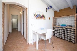 a dining room with a white table and chairs at VILLA BIFAMILIARE SCOPELLO in Scopello