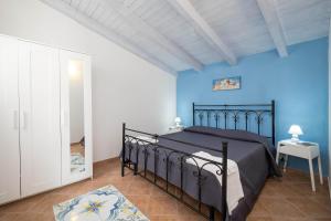 a bedroom with a black bed and blue walls at VILLA BIFAMILIARE SCOPELLO in Scopello