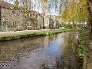 een rivier in een dorp met huizen en bomen bij Honeybun in Osmington