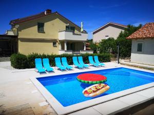 a swimming pool with chairs and a hot dog in it at Lavanda Apartments&Studios in Pinezici