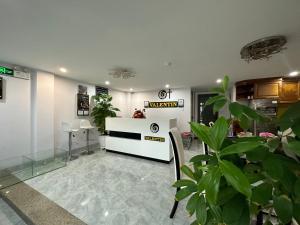 a waiting room with a counter and some plants at OYO 1190 Valentin Hotel in Da Nang