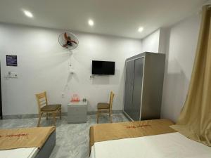 a room with two beds and a tv and two chairs at OYO 1190 Valentin Hotel in Da Nang